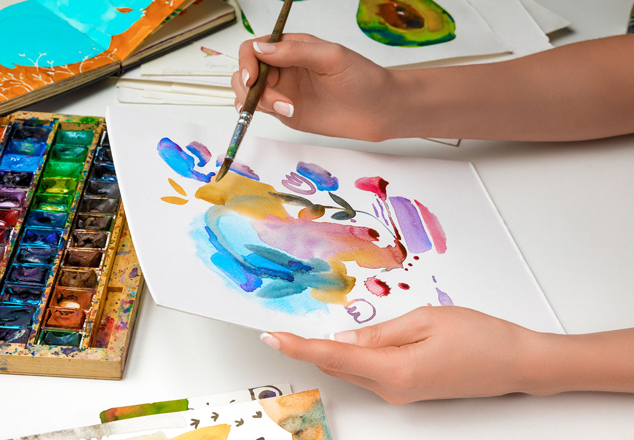 A hand painting abstractly in watercolor